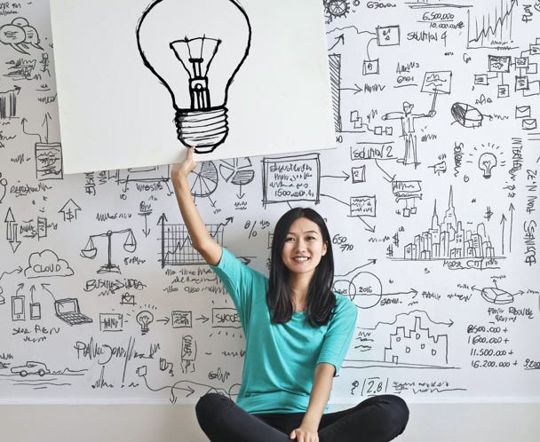 Woman Draw a Light bulb in White Board